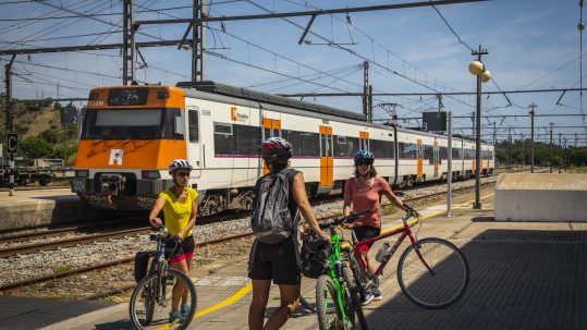 Ciclistas consultando los horarios de trenes en la estación de AVE de Girona